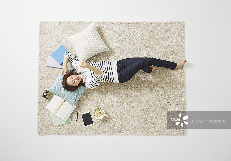 女人躺在地毯上休息的照片图片素材