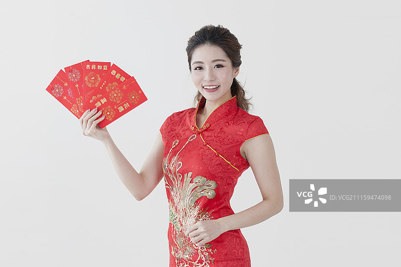 年轻女人穿旗袍拿着红包图片素材
