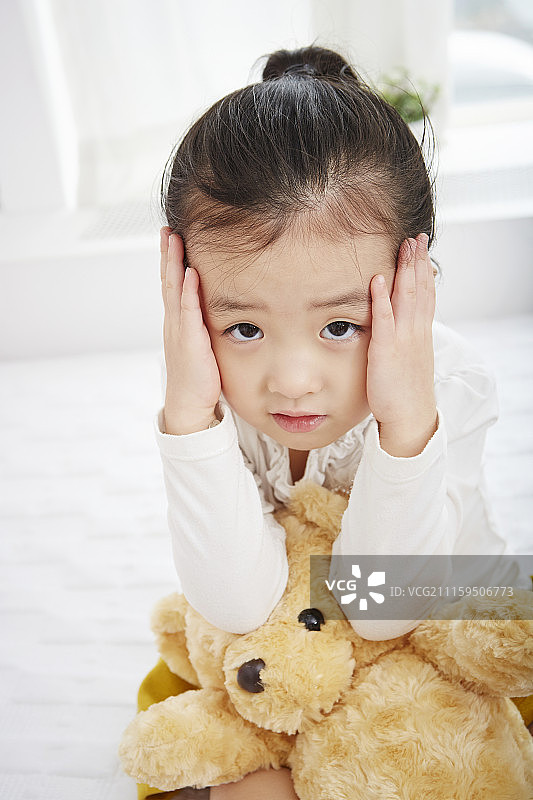 小女孩抱着痛苦的泰迪熊的照片图片素材
