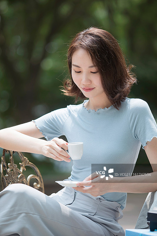 一个年轻女孩在喝咖啡图片素材