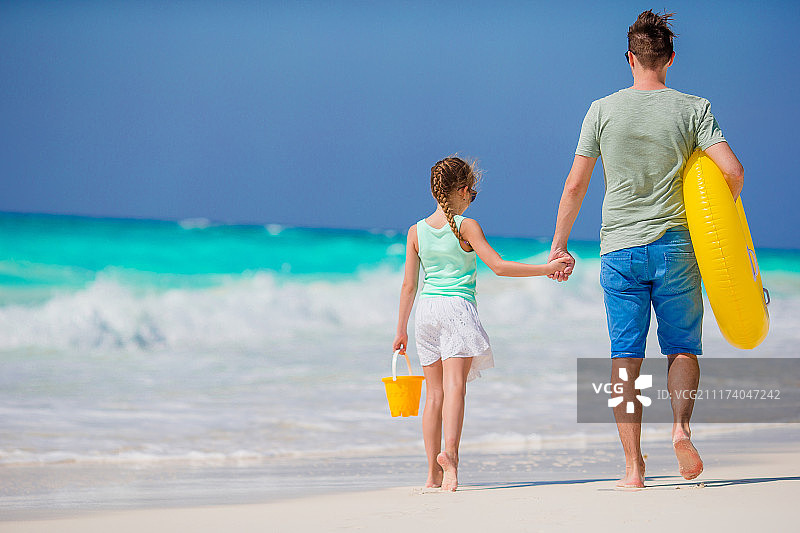 爸爸和小女孩一起在热带海滩图片素材