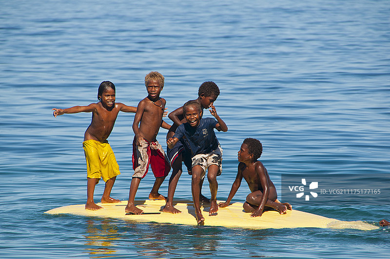 大洋洲所罗门群岛中部省萨伏岛，孩子们在玩冲浪板图片素材