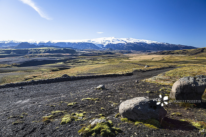 后板显示在冰岛的黑色火山岩景观土路与山脉图片素材