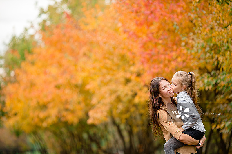 母亲和孩子的家庭在公园在秋天的一天图片素材