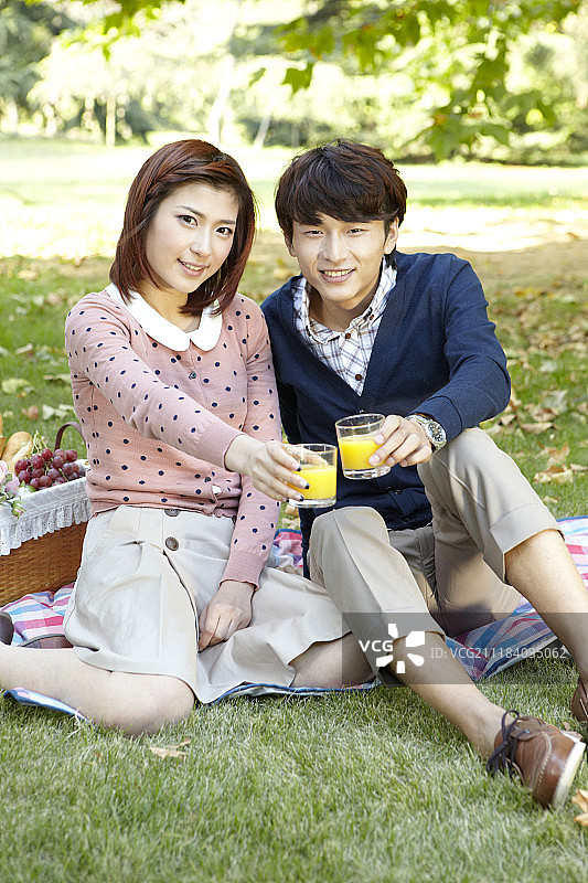 一对夫妇在草地上享受野餐的照片图片素材