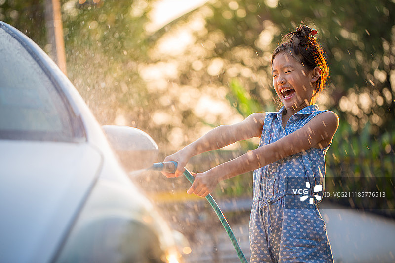 快乐的亚洲女孩洗车溅水图片素材