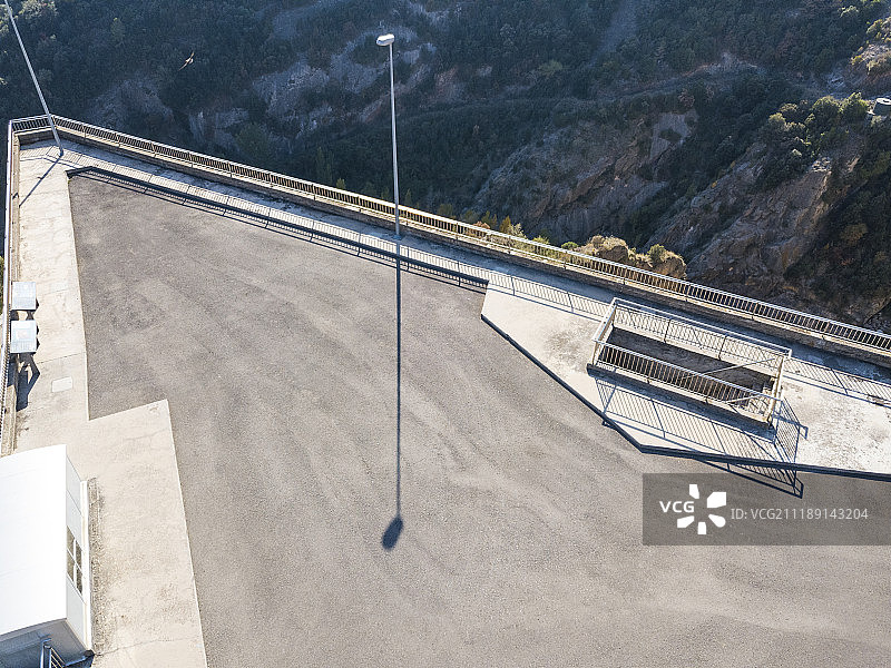 后板显示在西班牙山区的一个水坝顶部的柏油路图片素材