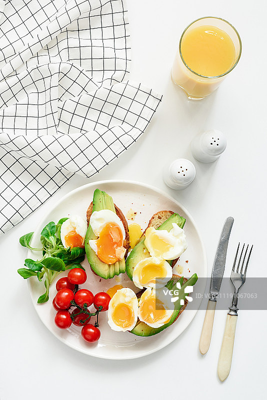 早餐吃健康的牛油果、鸡蛋吐司和橙汁图片素材
