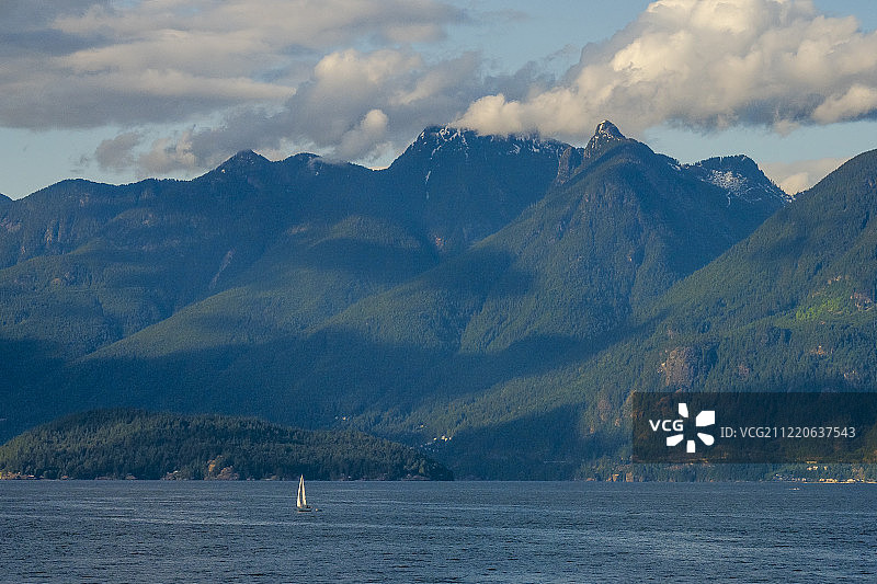 远眺帆船航行在近海附近的山脉，温哥华，不列颠哥伦比亚省，加拿大图片素材