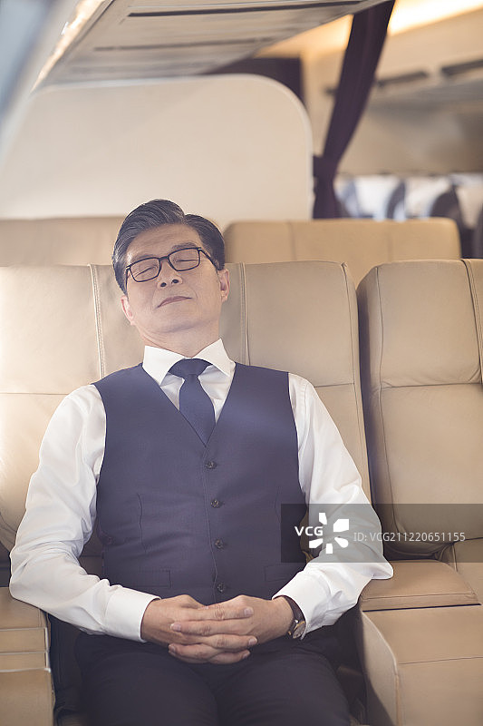 商务男士在机舱休息图片素材