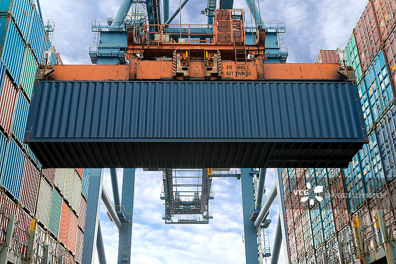 在货船上装载集装箱的工业起重机图片素材