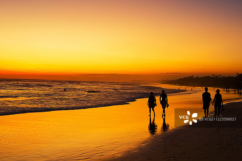 人们漫步海洋海滩日落图片素材