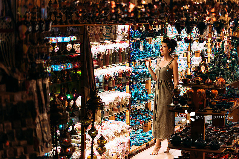 土耳其一家纪念品商店里的漂亮女孩。女孩选择了一家东方纪念品店。街店……图片素材
