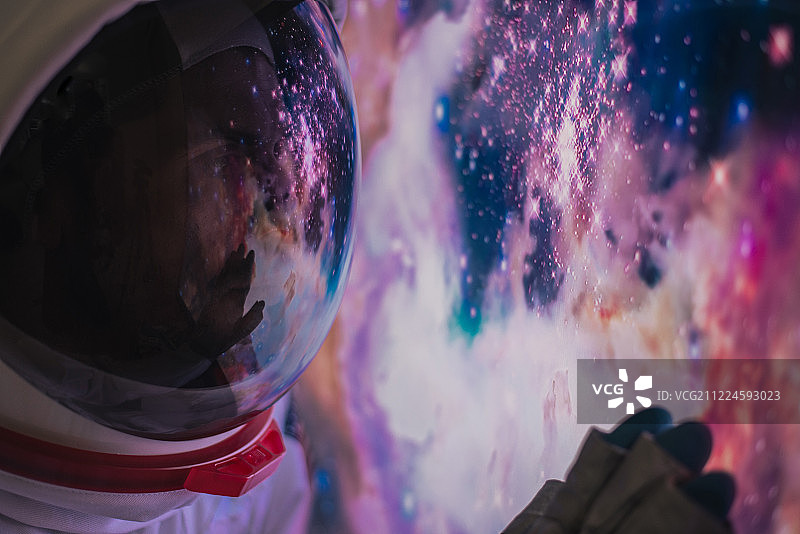 宇航员从窗口观察外太空，银河系和行星图片素材