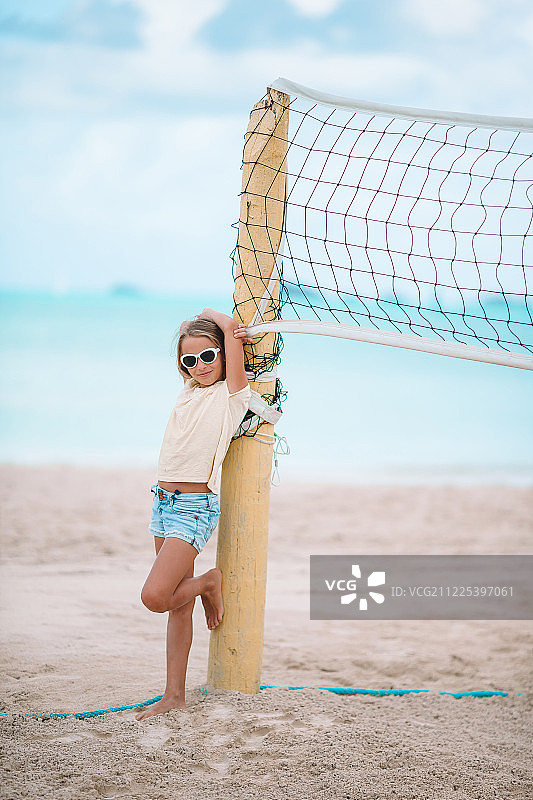 可爱的小女孩在沙滩上玩排球图片素材