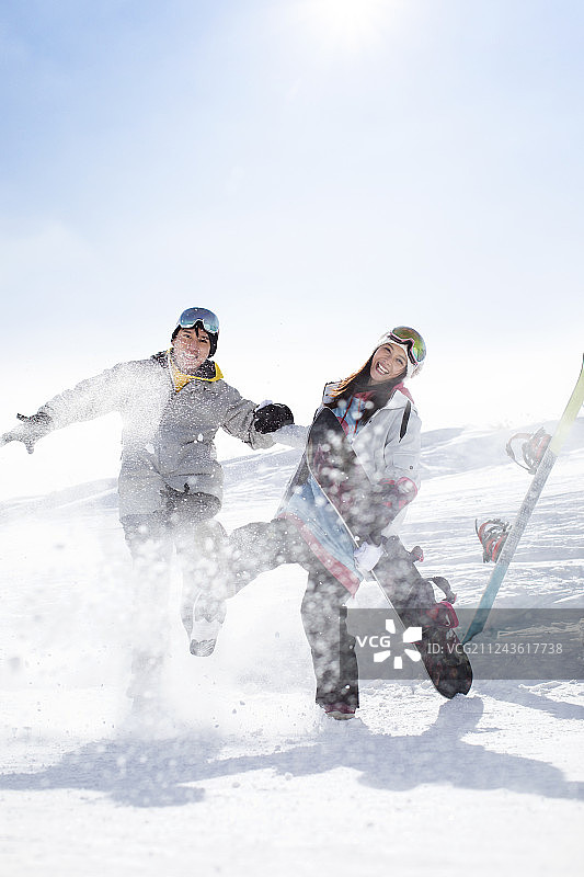 快乐的年轻情侣在滑雪场滑雪图片素材