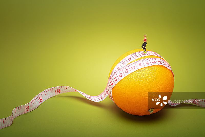 美女在卷着皮尺的橙子上跑步减肥瘦腰瘦身健康生活健身图片素材