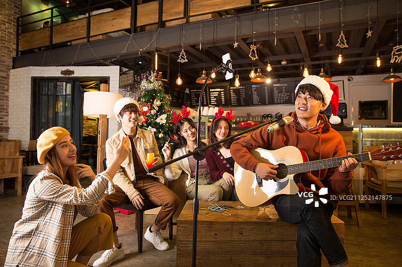 五个青年男女在酒吧弹吉他唱歌喝酒一起欢度圣诞节平安夜图片素材