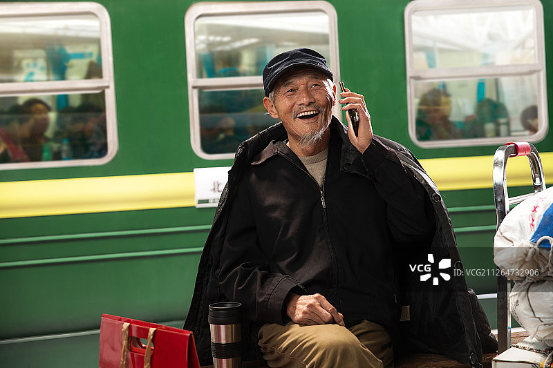 在火车站台上打电话的老人图片素材