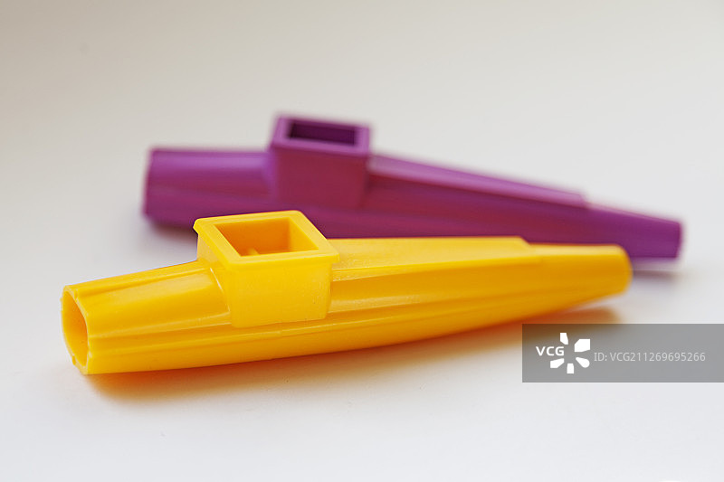 黄色和紫色卡祖笛在白色的背景图片素材