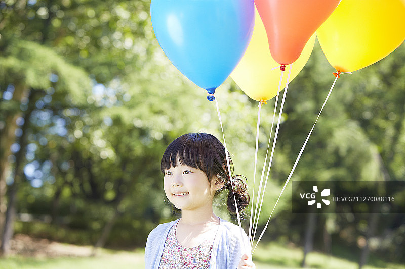 小女孩在公园里拿着气球的照片图片素材