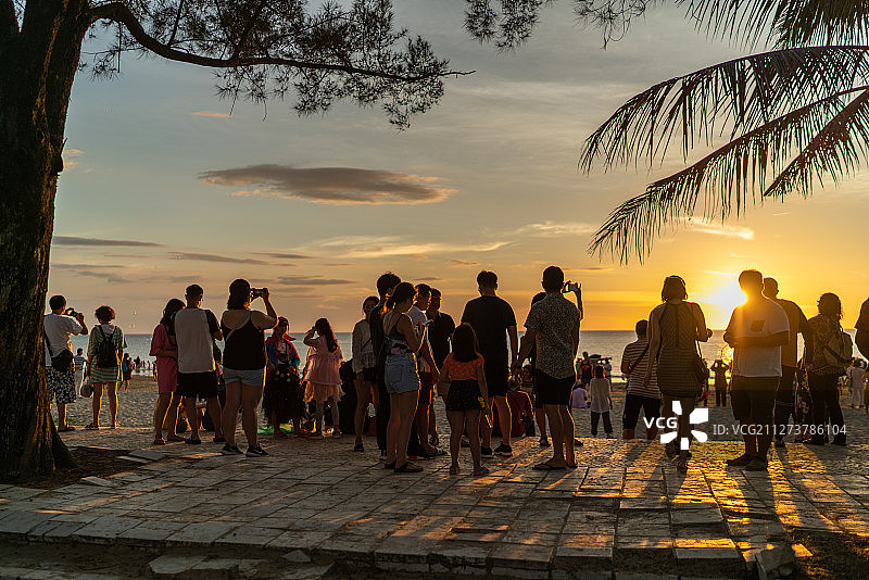 丹绒亚路海滩上看日落的一群人图片素材