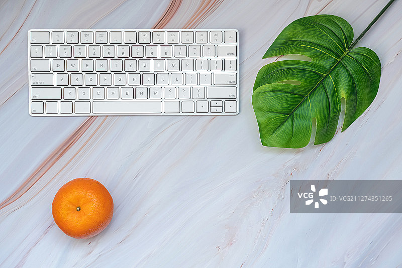 桌面上的键盘和橘子图片素材