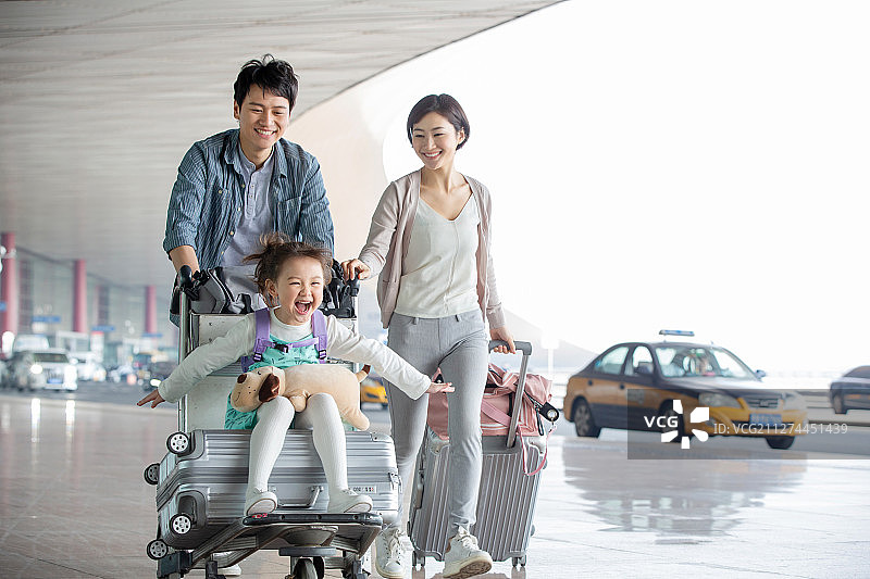 快乐家庭推着行李在机场图片素材