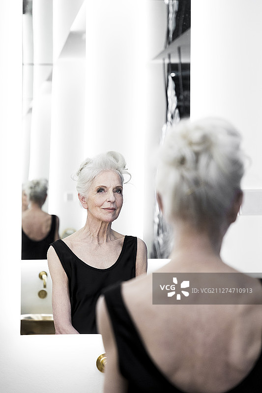 优雅的老妇人坐在镜子前图片素材