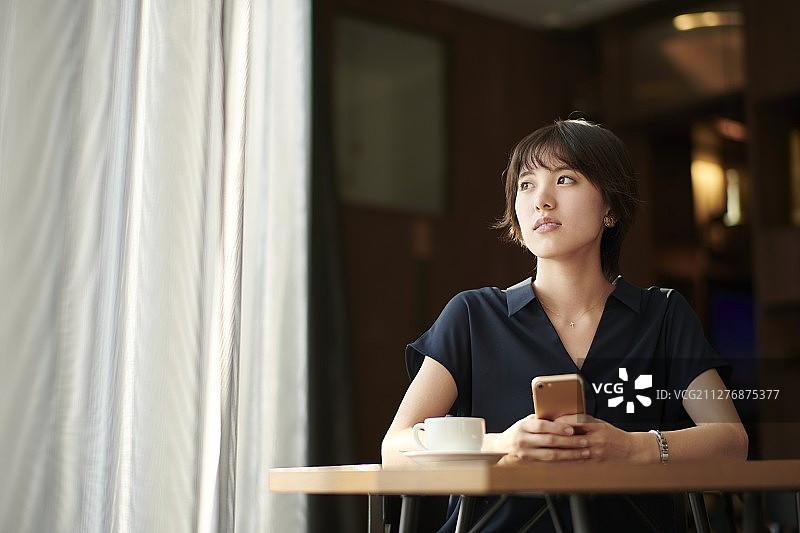 一个年轻的日本女人在咖啡馆图片素材