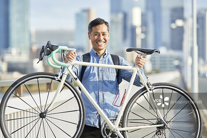 日本大阪市区，成熟的日本男人骑着自行车图片素材