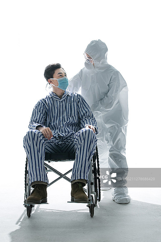 医务工作者推着坐轮椅的患者图片素材