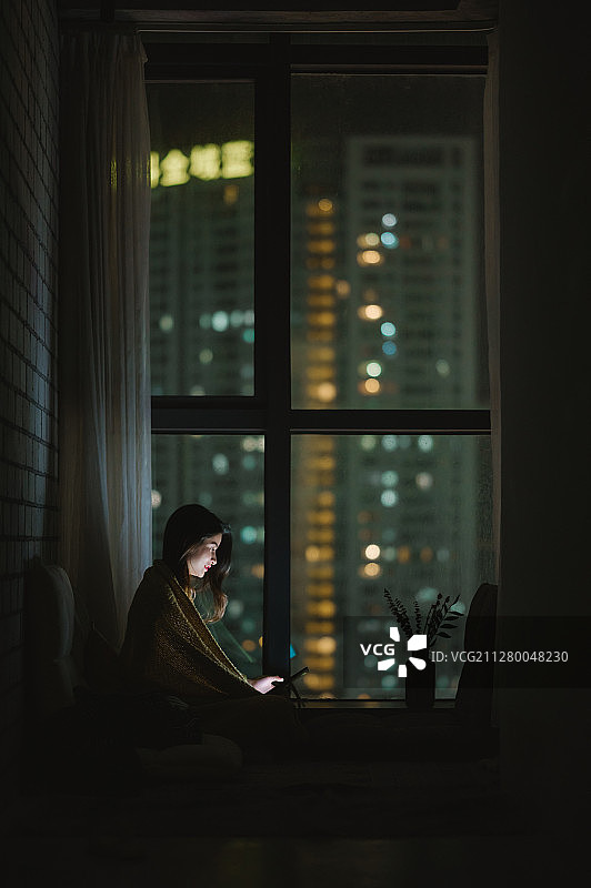 亚洲年轻女孩夜晚在家使用笔记本电脑图片素材