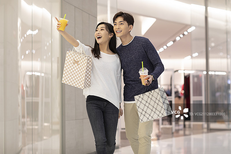 快乐的年轻情侣在商场购物图片素材