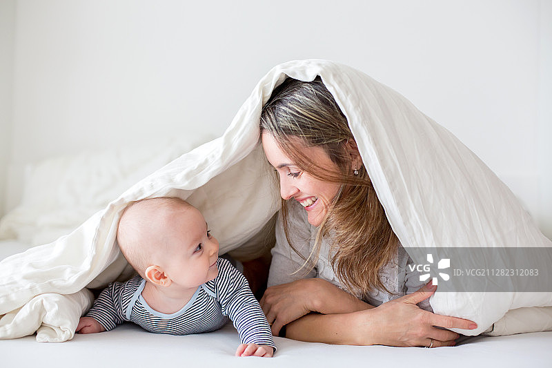 母亲和婴儿躺在床上图片素材