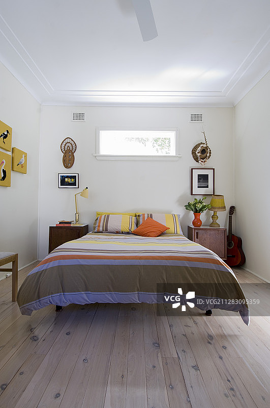 卧室双人床，带条纹床罩和床头柜图片素材