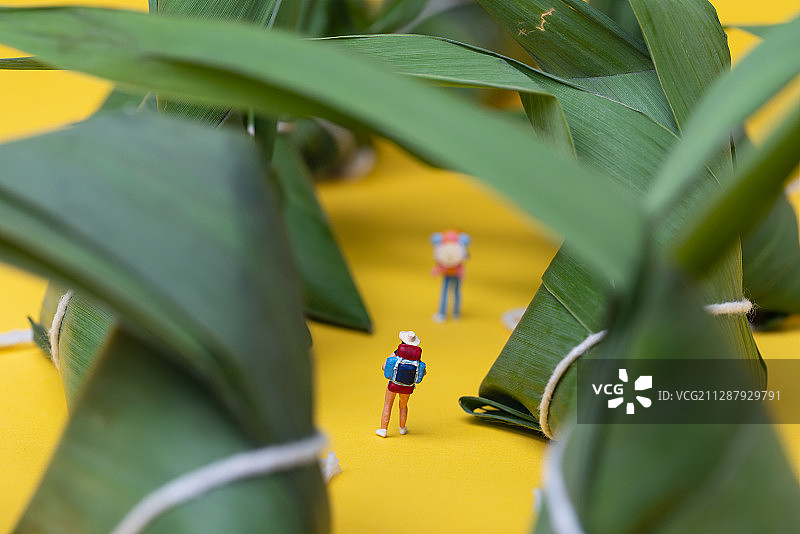端午节-粽子与背包人物模型在黄色背景上图片素材