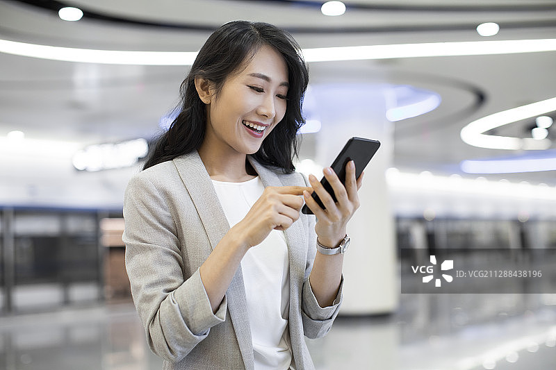 年轻商务女士在机场使用手机图片素材