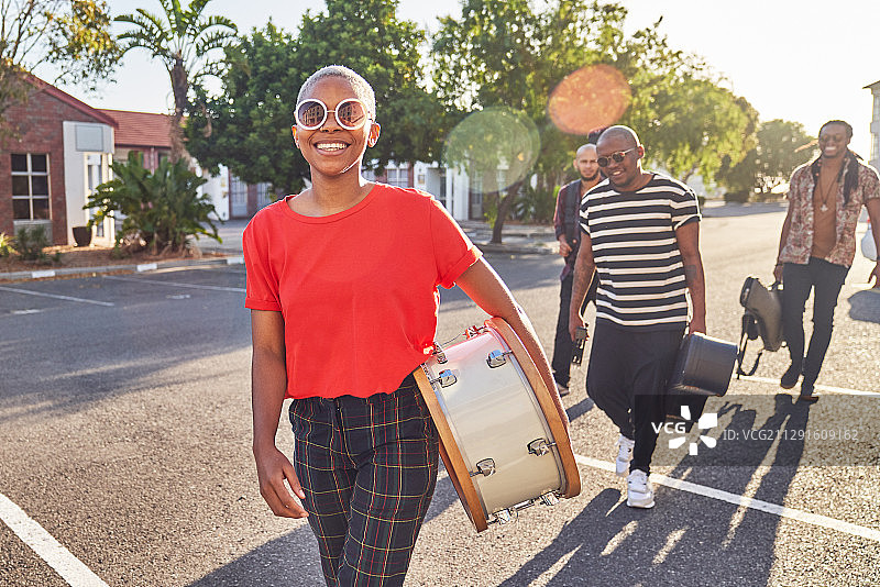 描绘快乐的音乐家扛着乐器在阳光大道上图片素材