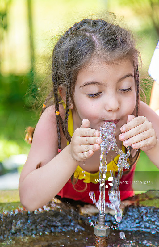 格鲁吉亚Borjomi，一个小女孩在喝泉水图片素材