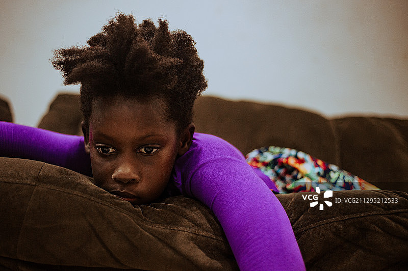 躺在家里沙发上的黑人女孩的肖像图片素材