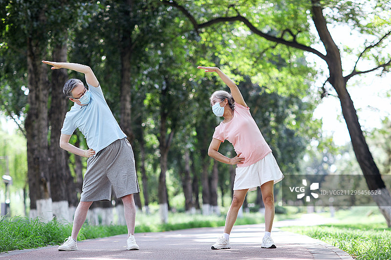 老年夫妇戴着口罩在公园运动图片素材