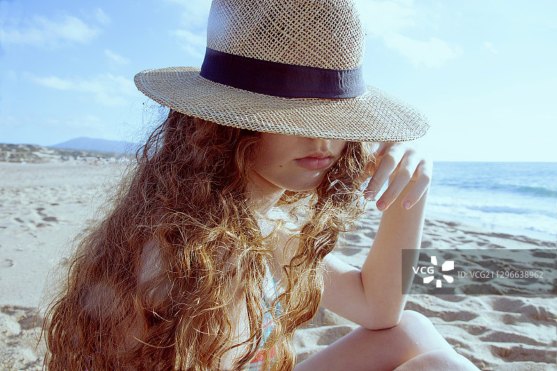 在意大利皮西纳斯的沙滩上，戴着帽子的白人少女图片素材