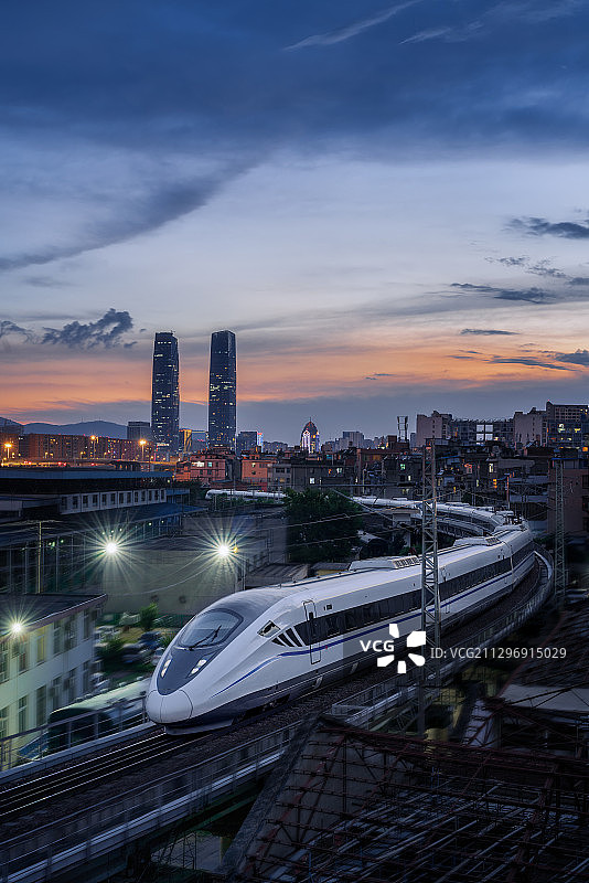 日落黄昏时穿越城市的高速列车图片素材