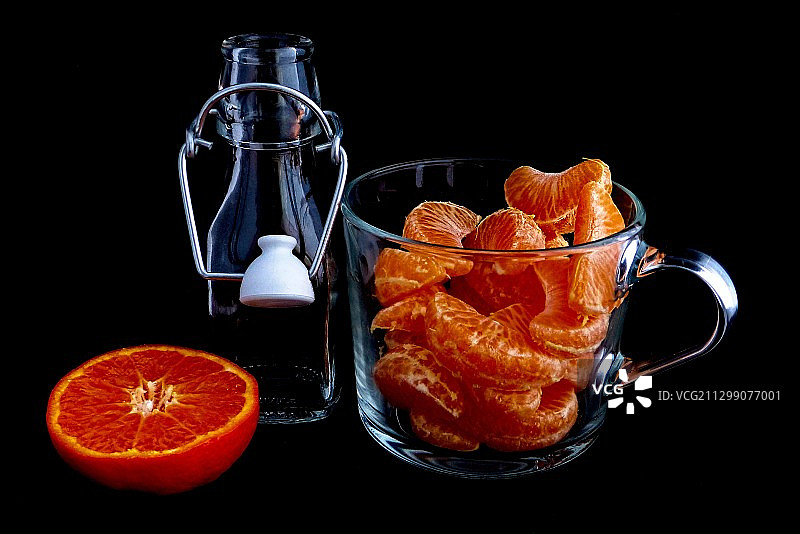 波兰华沙，黑色背景下的橙色水果和杯子里的饮料图片素材