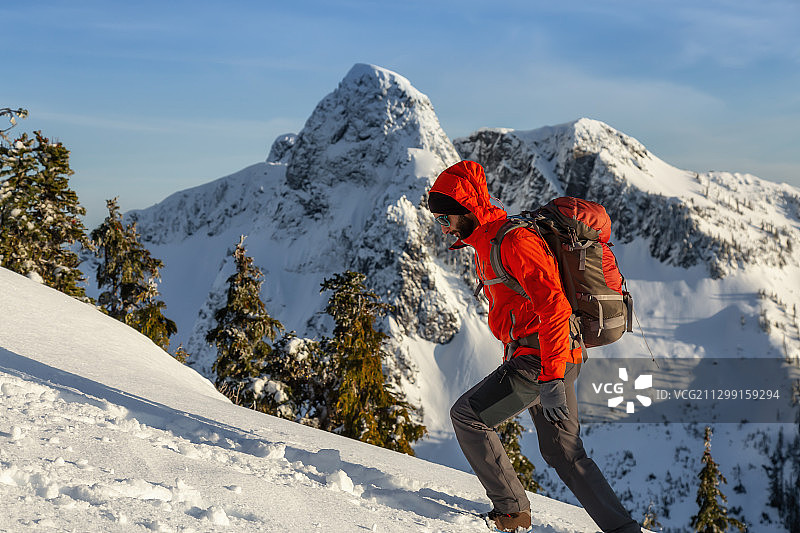 一名男子在雪山徒步旅行图片素材