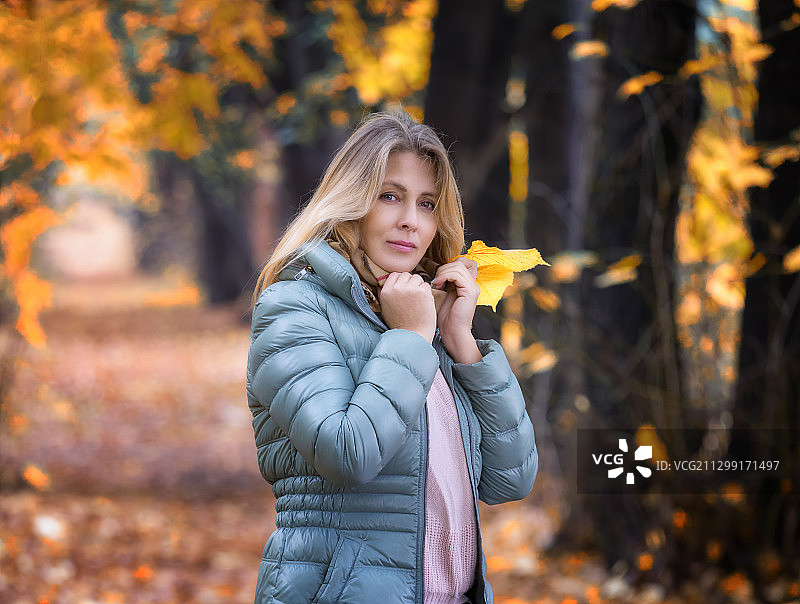 秋天里站在森林里的女人的肖像图片素材