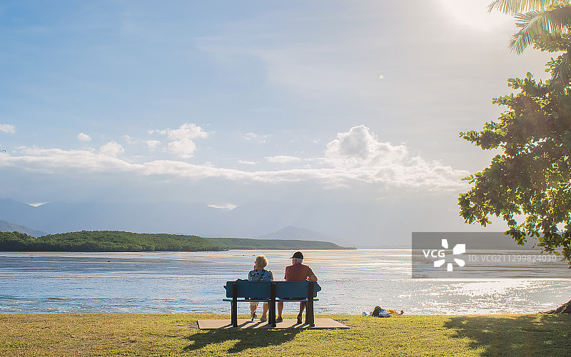一对幸福老夫妻坐在澳大利亚道格拉斯港海边长椅上图片素材