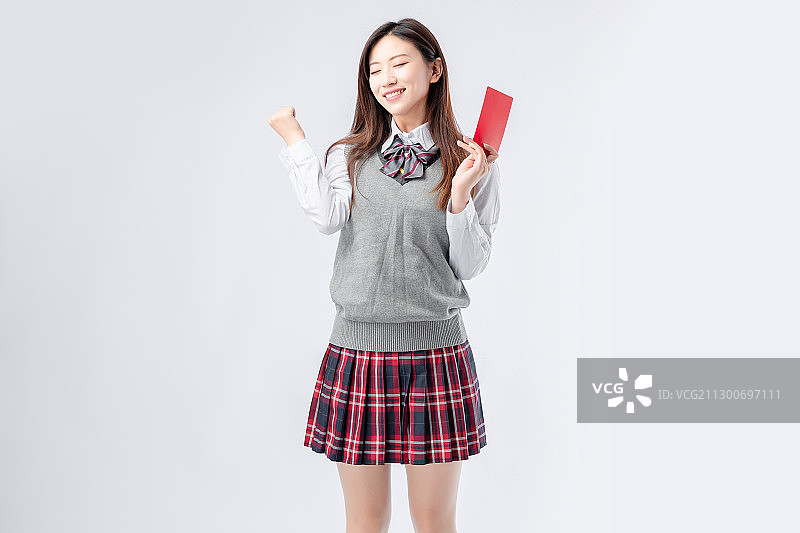 身穿校服,手里拿着红包的亚洲女孩图片素材