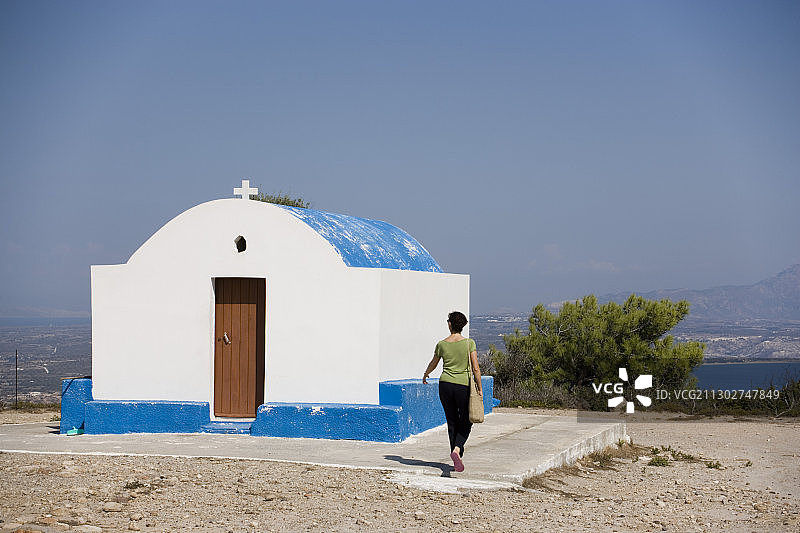 在希腊科斯科斯科法洛斯附近，一名妇女正在参观帕纳吉亚齐尼奥提萨教堂图片素材